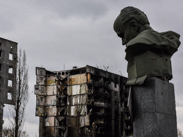 A picture of a war-torn building and statue in Ukraine.