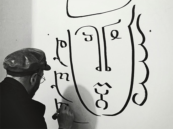 A black-and-white photo of Shota Saganelidze drawing on a canvas.