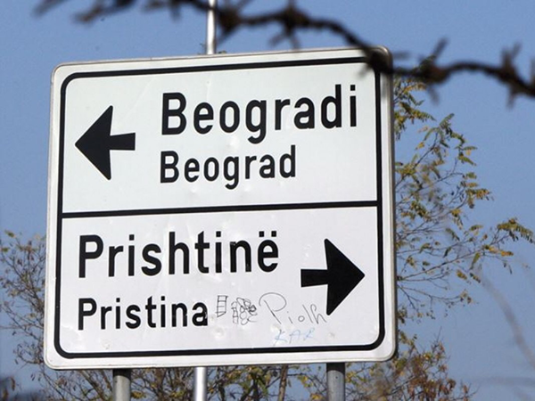 A road sign with one arrow pointing toward Beograd and another toward Pristina.