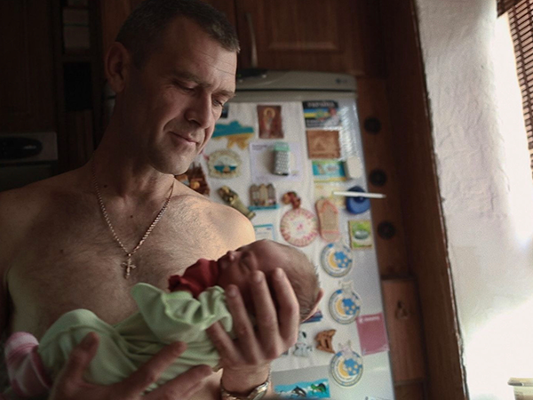 Man holding a baby. Image links to event page.